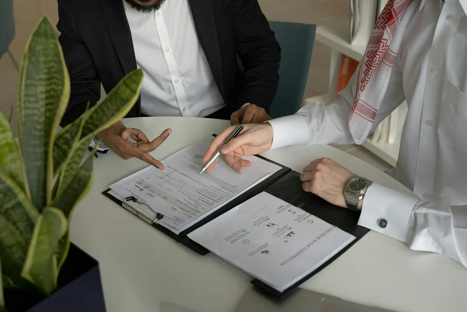 Two people going through printed documents at a table